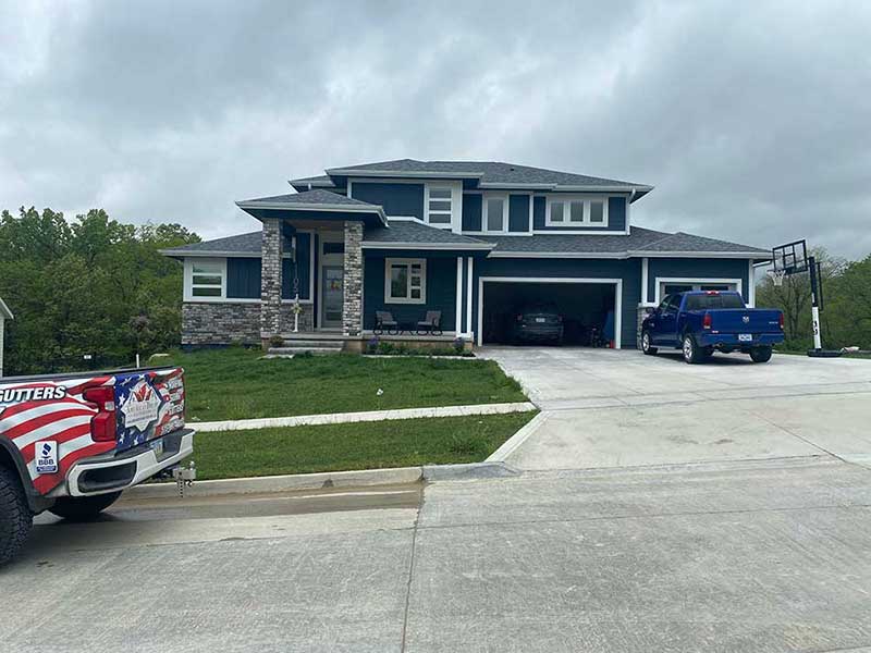 American Dream Exteriors work pickup parked in front of a mid-class residential home with brand new gray shingles installed by the team
